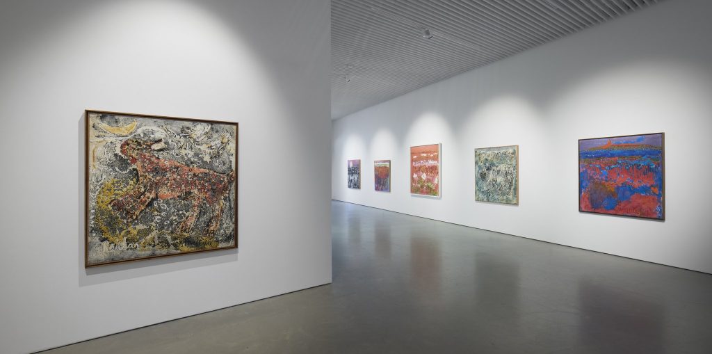 Näkymä Reidar Särestöniemi -näyttelystä. Eri värisiä ekspressiivisiä maalauksia ripustettuna valkoisille seinille.