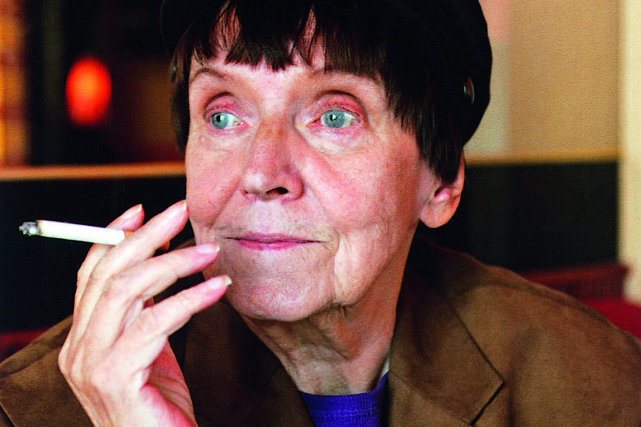 Kirjailija Mirkka Rekola istuu savuke kädessä.